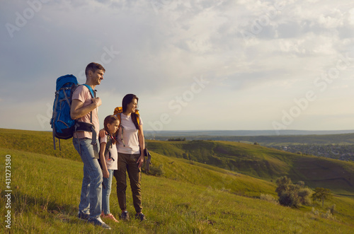 Family of backpackers in mountainous valley in summer nature