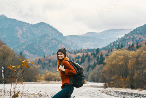 woman in a jeans sweater with a backpack rest in the mountains near the river in nature © SHOTPRIME STUDIO