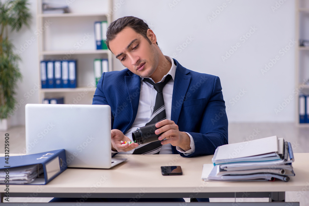 Sick male employee suffering at workplace Sick male employee suffering at workplace