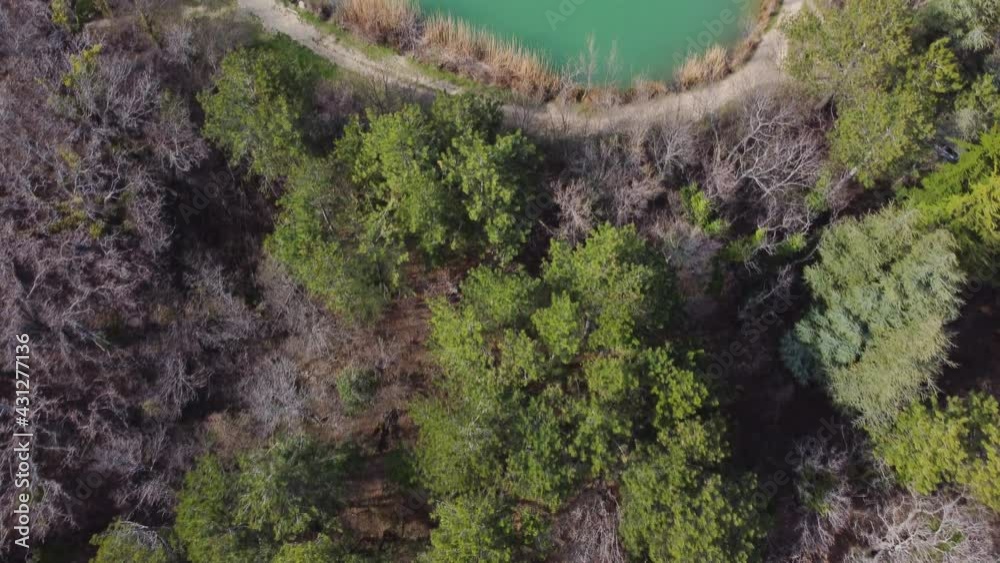 Top view of the spring forest and a beautiful small blue lake in the mountains. Stock footage. Drone flight over a mountain forest, stunning views. Crimean beauty peninsula. Top view of the spring forest and a beautiful small blue lake in the mountains. Stock footage. Drone flight over a mountain forest, stunning views. Crimean beauty peninsula.