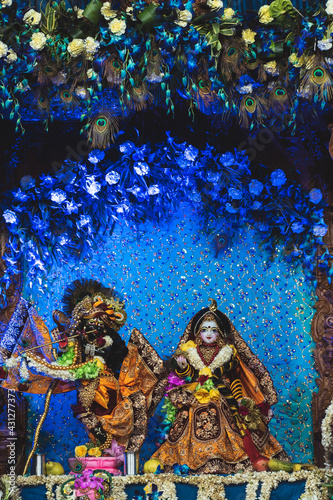 Beautiful idol of Lord Krishna and goddess Radha decorated with flowers, clothes and jewellery during Janmashtami celebration. 