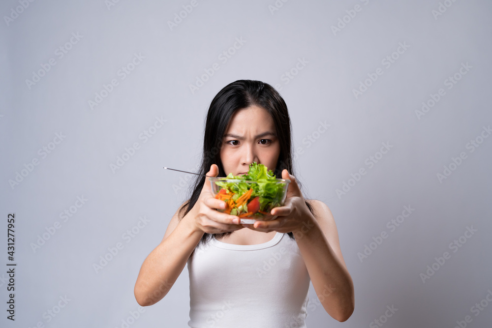 Asian woman eating salad for diet isolated over white background. Asian woman eating salad for diet isolated over white background.