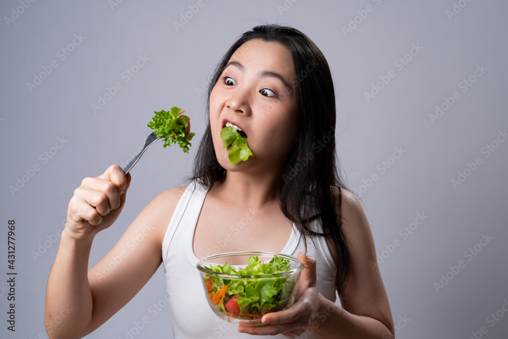 Asian woman eating salad for diet isolated over white background. Asian woman eating salad for diet isolated over white background.