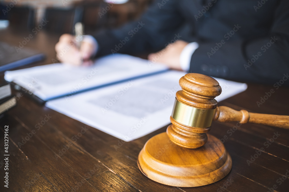 Lawyer preparing to sign a contract and wooden gavel on table justice and law concept. Lawyer preparing to sign a contract and wooden gavel on table justice and law concept.