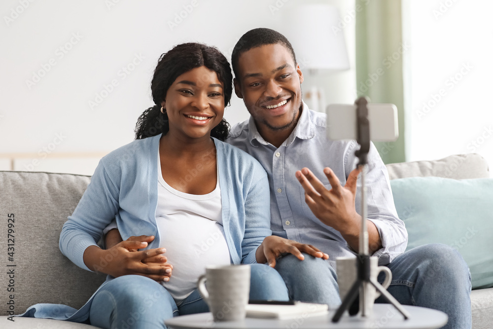 Cheerful black bloggers broadcasting from home, pregnancy blog concept Cheerful black bloggers broadcasting from home, pregnancy blog concept