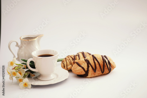 French breakfast on the table. Coffee croissant with chocolate and a decanter with cream. Fresh pastries and decaffeinated coffee.