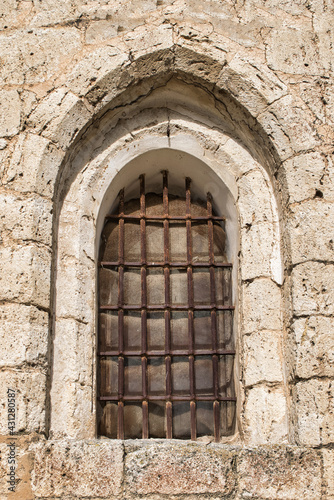 Ventana en arco apuntado de estilo rom  nico siglo XII con barrotes de hierro en la iglesia Santiago ap  stol de Villalba de los Alcores  provincia de Valladolid  Espa  a