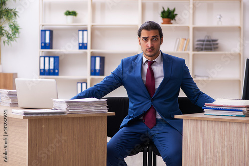 Young male employee in multitasking concept