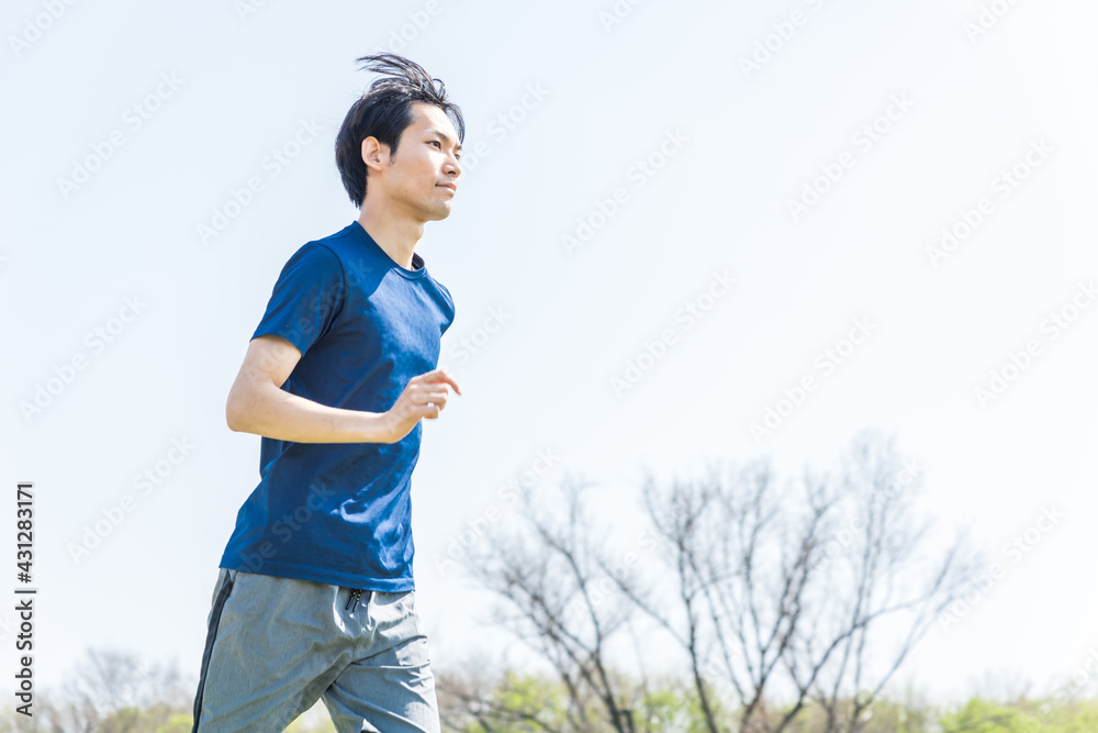 公園でランニングをする若い男性 公園でランニングをする若い男性