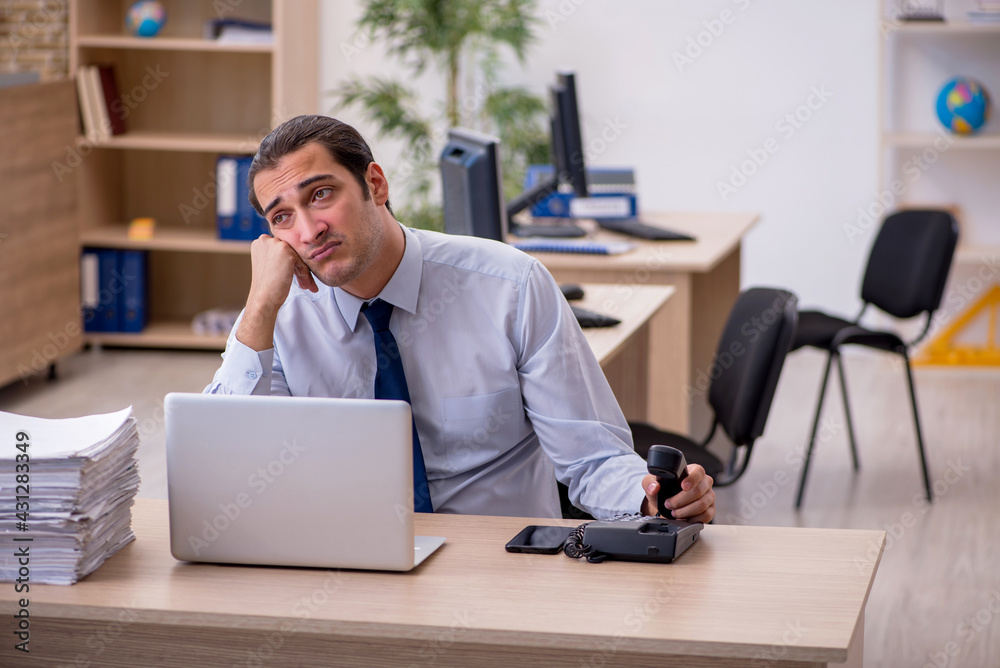 Young male employee sitting in the office Young male employee sitting in the office