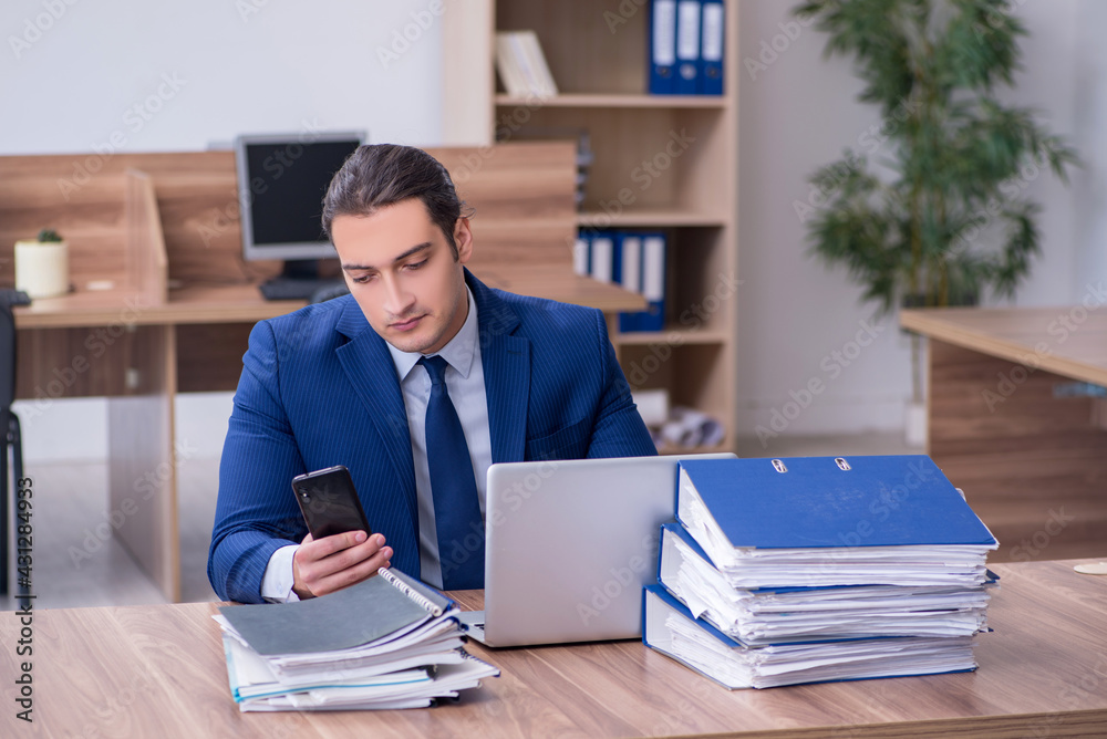 Young male employee unhappy with excessive work Young male employee unhappy with excessive work