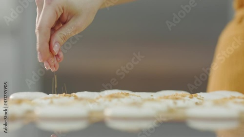 Pastry chef girl prepares fresh cakes at her small production facility