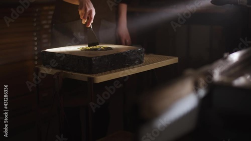Close up of a man preparing a yellow paint in a book workshop. Artist at work, mixing coloured paint, painter at work. Hobby and creativity concept, hands of a man working with wood at night.
