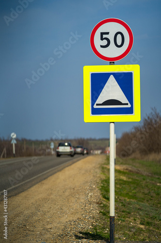 road sign for roughness on the road. close up shot. road sign speed limit 50 km pes hour