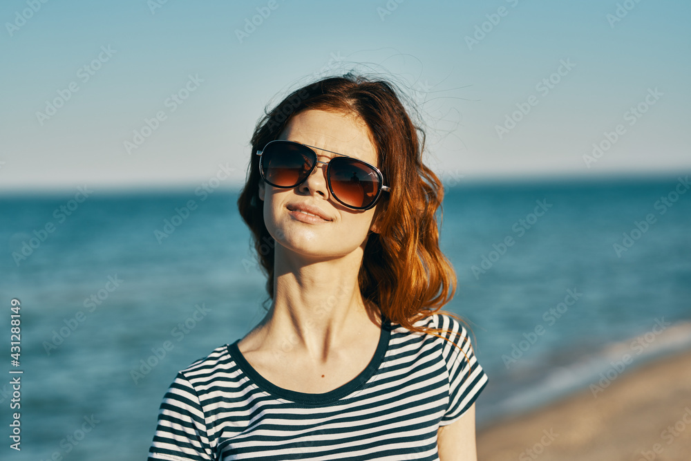 pretty woman model in sunglasses by the sea in the mountains