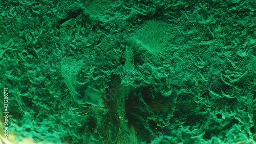 Toxic waste in slow motion, chemicals boiling, strange, green liquid creating bubbles in chemical reaction. Gritty, dark background, chemistry under a microscope in slow motion.
