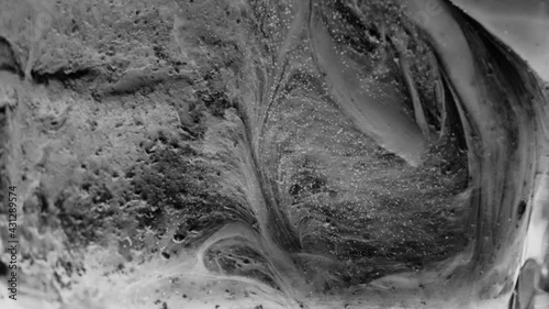 Abstract, gritty black and white background. Horror, thriller background, eerie moving substances in slow motion. Creepy macro scene.