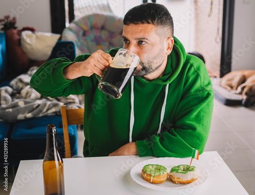 Un hombre soltero desayunando rosquillas y cerveza negra para celebrar el Día de San Patricio 