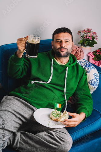 Un hombre soltero desayunando rosquillas y cerveza negra para celebrar el Día de San Patricio 