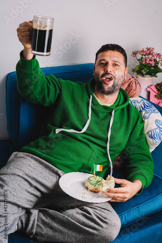 Un hombre soltero desayunando rosquillas y cerveza negra para celebrar el Día de San Patricio 