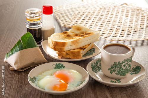 Oriental breakfast set in Malaysia consisting of coffee, nasi lemak, toast bread and half-boiled egg photo
