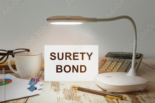 Desktop with a lamp that illuminates the inscription Surety Bond