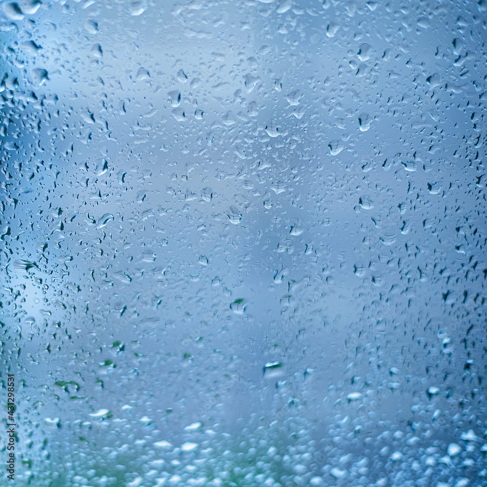 Drops of rain on the window glass. Shallow DOF. Window after rain. Blue Water background with water drops. Drops of rain on the window glass. Shallow DOF. Window after rain. Blue Water background with water drops.