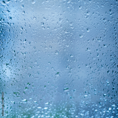 Drops of rain on the window glass. Shallow DOF. Window after rain. Blue Water background with water drops.