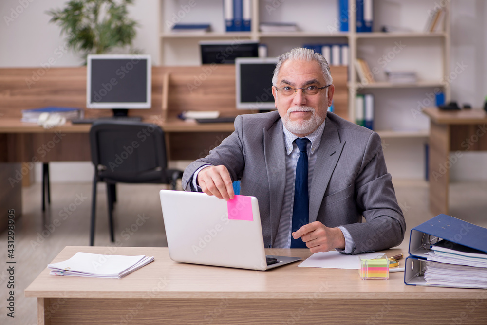 Old male employee working in the office Old male employee working in the office