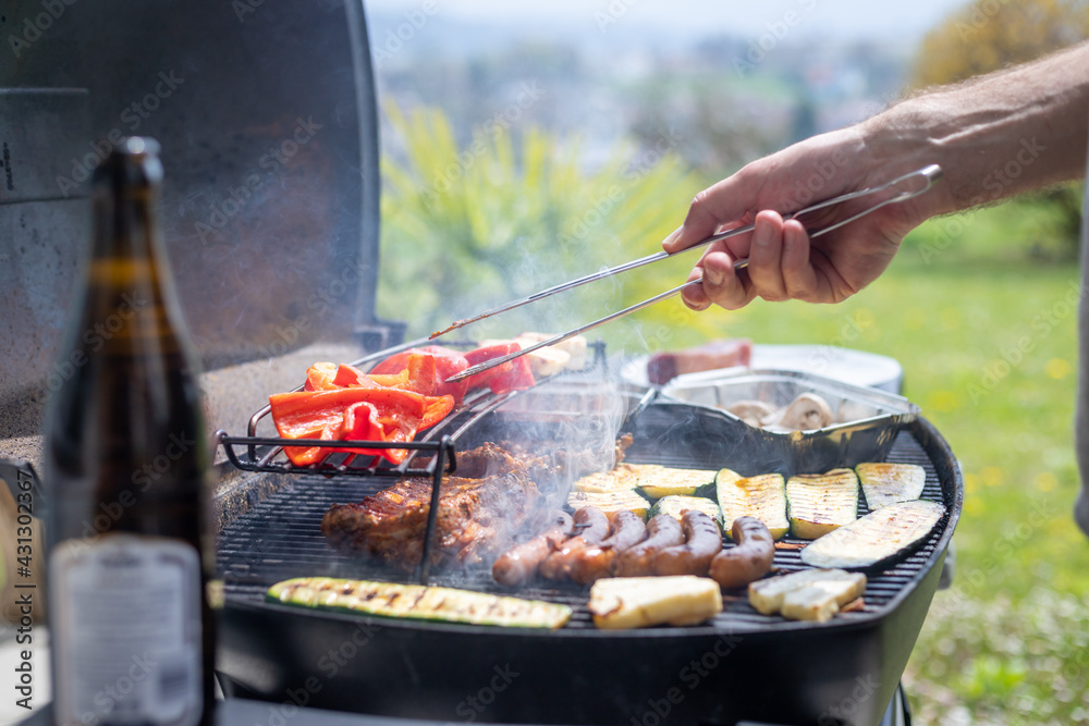 Fototapeta premium BBQ on weekend. Sausages, steak, cheese and vegetables on gas grill. Outdoors.