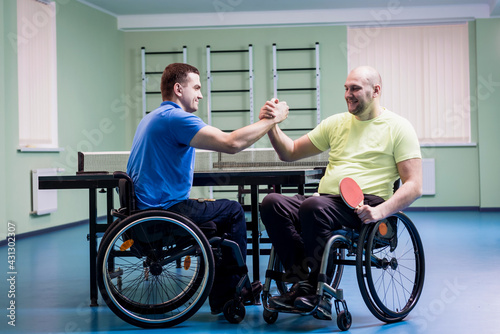 Disabled adult men shaking hands after playing table tennis © romaset