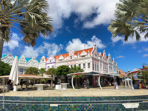 Lively busy street scenery on shopping mall avenue with people on tropical Caribbean Island with picturesque colorful houses and facades, shops and boutiques for souvenirs during cruise vacation holid photo