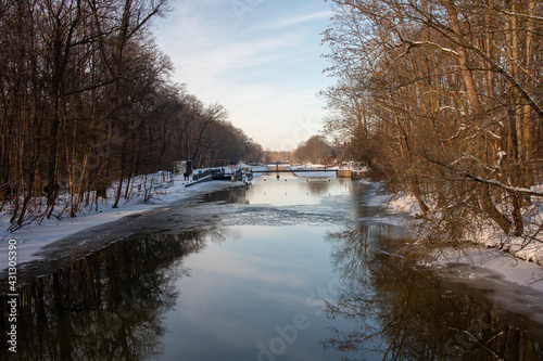 Fototapeta Naklejka Na Ścianę i Meble -  Winter view of the icy and snowy park and river landscapes in Leipzig, Saxony, Germany b