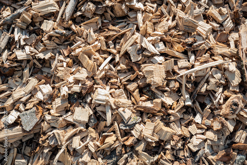 Closeup of a large heap of shredded wood after the felling of a large number of tall trees. The heap is waiting for transport to the combined heat and power plant.