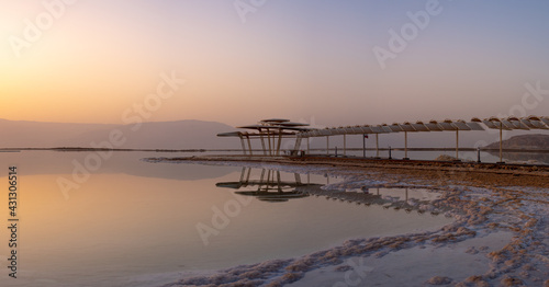 Shade Umbrella reflection at sunrise at the Dead Sea in Israel