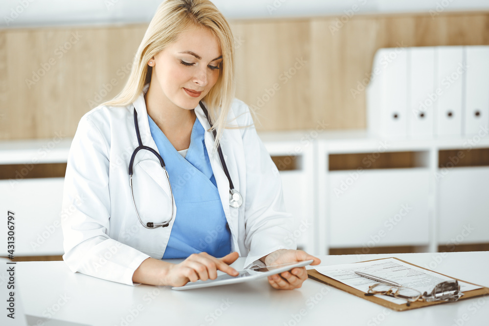 Woman-doctor standing in hospital or clinic and using tablet pc. Data and best service in medicine and healthcare Woman-doctor standing in hospital or clinic and using tablet pc. Data and best service in medicine and healthcare