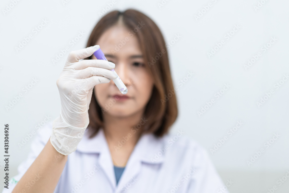 A young woman researcher, doctor, scientist, or laboratory assistant working with plastic medical tubes to research, examine scientific experiments in a modern laboratory. Education stock photo A young woman researcher, doctor, scientist, or laboratory assistant working with plastic medical tubes to research, examine scientific experiments in a modern laboratory. Education stock photo