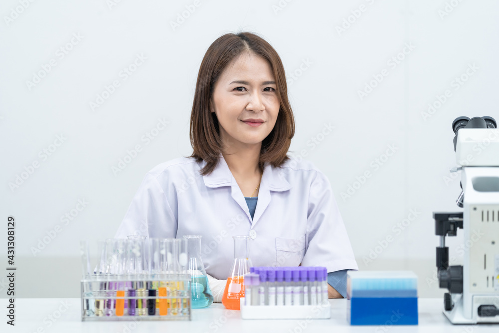A young woman researcher, doctor, scientist, or laboratory assistant working with plastic medical tubes to research, examine scientific experiments in a modern laboratory. Education stock photo A young woman researcher, doctor, scientist, or laboratory assistant working with plastic medical tubes to research, examine scientific experiments in a modern laboratory. Education stock photo