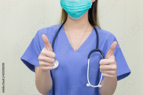 Woman doctor wearing medical face mask showing sign