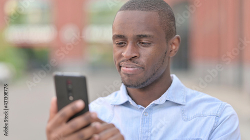 Portrait of Positive African Man using Smartphone 