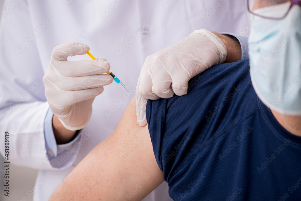 Old male patient visiting young male doctor in vaccination conce Old male patient visiting young male doctor in vaccination conce