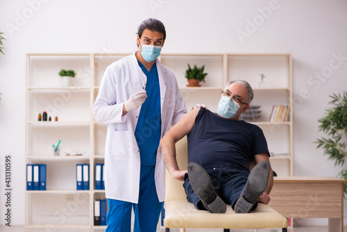 Old man visiting young doctor in covid-19 vaccination concept