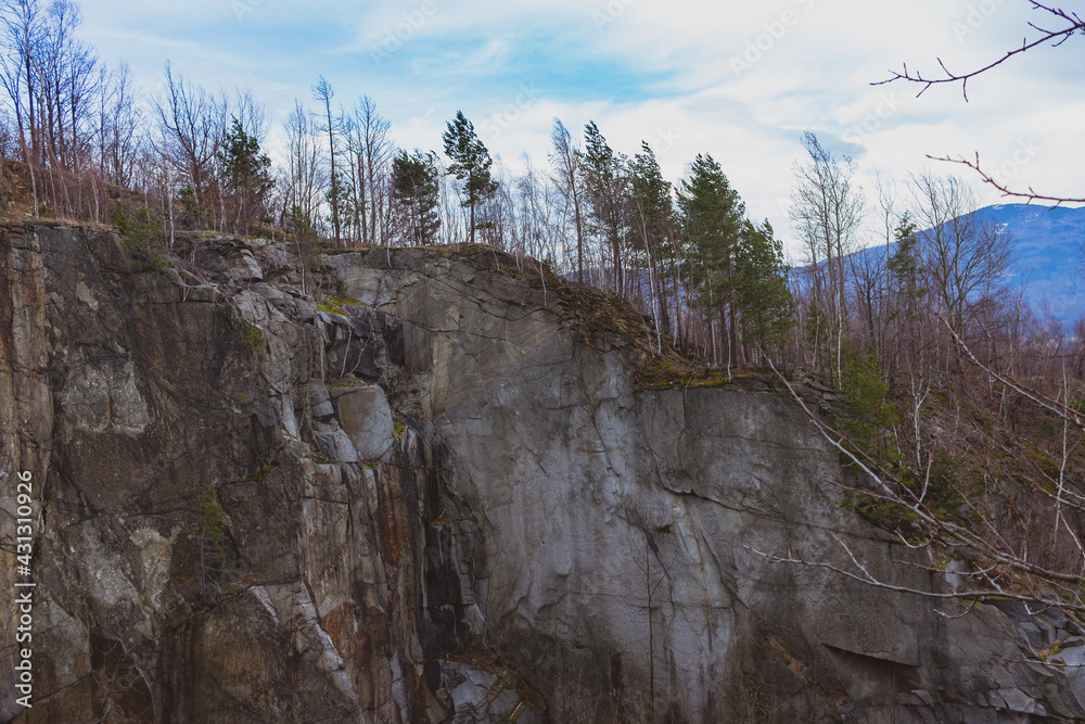 Old quarry in the mountains with trees on the slope Old quarry in the mountains with trees on the slope