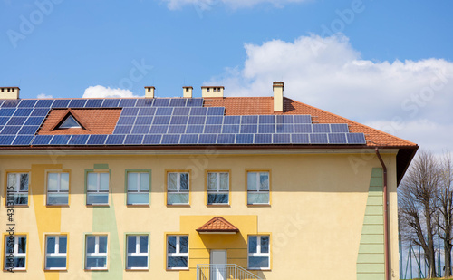 solar panels on roof of school building, renewable sources of solar power and energy