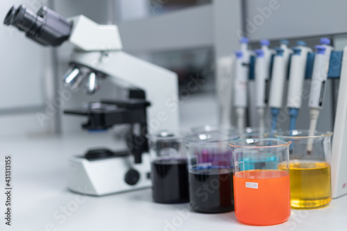 Close-up and selective focus shoot of a microscope, medical test tubes with liquid, and other modern laboratory equipment in a laboratory room. Education stock photo