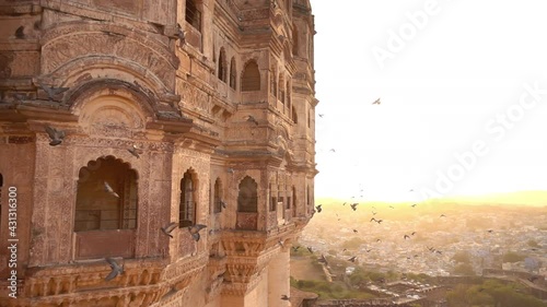 Slow motion video of some pigeons flying over the Udaipur City Palace during a stunning sunset. Udaipur, Rajasthan, India.