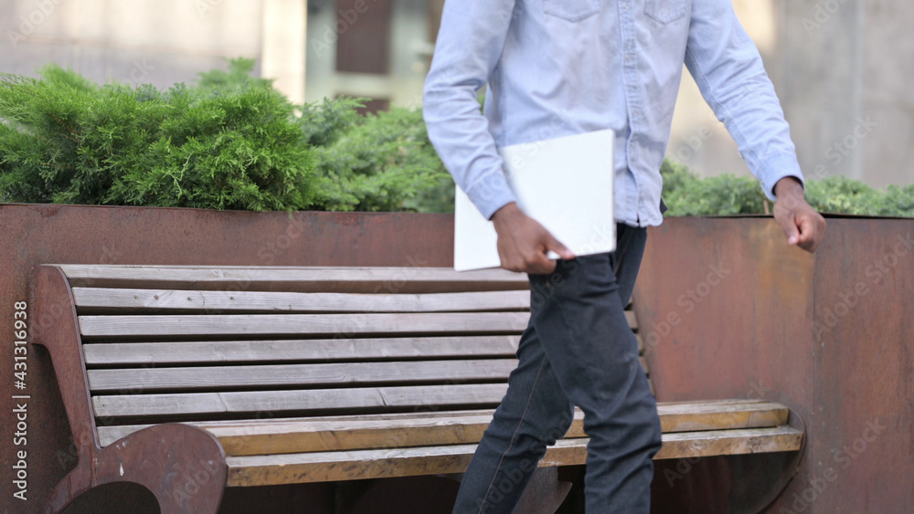 African Man Standing up and Going Away from Outdoor Bench
