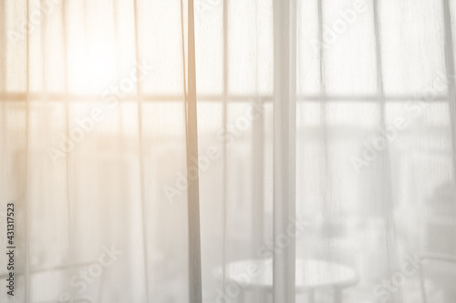 airy or thin and transparent white sheer curtain for see through and soft warm sun light on balcony close window in room for city home or hotel interior decor on morning feel and hot summer background