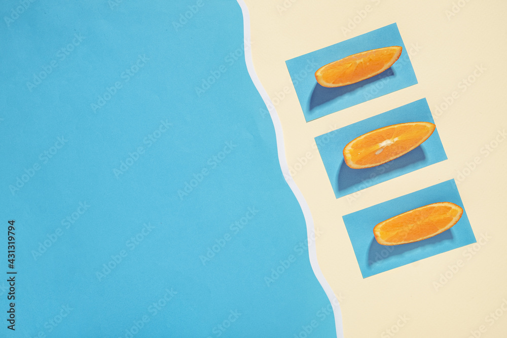 Fototapeta premium Three oranges sunbathe on the beach near the sea