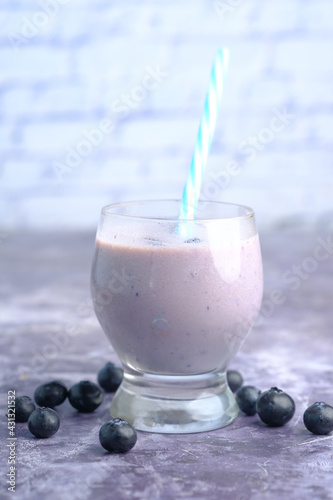 blue berry milk shake in a glass on table 